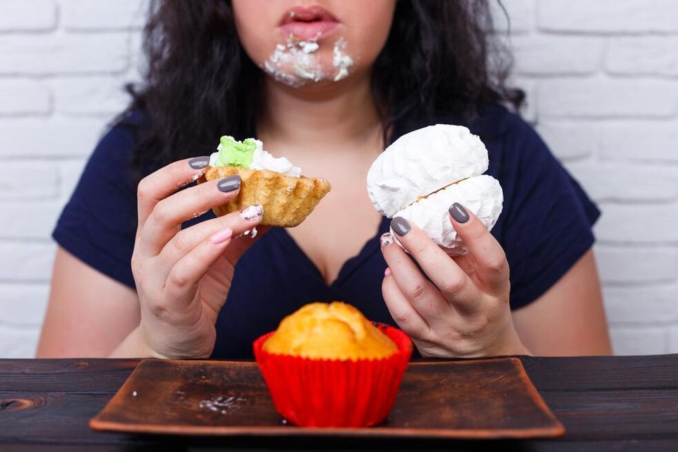Übergewichtige Frau isst Süßigkeiten